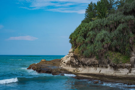 Pantai Klayar or Klayar Beach with rocks and strong waves against the blue sky. Motion blur. Landscape photography.の写真素材