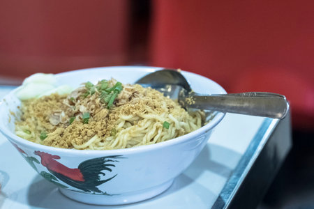 Mie Ayam is a popular Indonesian dish consisting of flavorful, savory chicken noodles. The dish typically features thin yellow noodles served in a flavorful broth or sauce, topped with tender slices of chicken, crispy fried shallots, and a variety of garnishes such as chopped spring onions and Chinese greensの写真素材