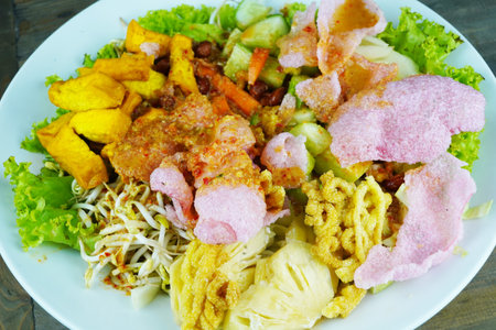 Asinan Betawi or Indonesian sour and spicy salad with peanut sauce and vegetable on wooden tableの写真素材