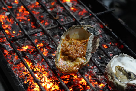 Grilled oyster at Jakarta Food Streets Vendor. Sizzling on a grill, plump oysters offering a taste...