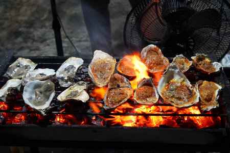 Grilled oyster at Jakarta Food Streets Vendor. Sizzling on a grill, plump oysters offering a taste of the sea with every bite.の写真素材