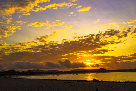 A breathtaking sunrise near Mandalika, Lombok, Indonesia paints the sky in fiery hues over a calm...