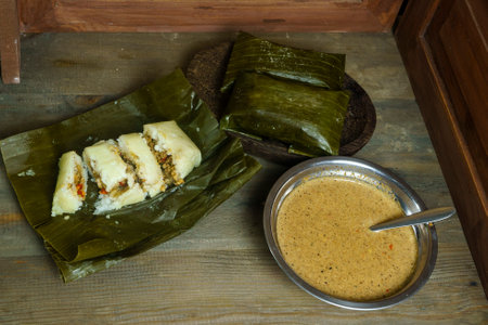 Lontong oncom, a traditional Indonesian dish with steamed rice cakes wrapped in banana leaves, served with spicy peanut sauce.の写真素材