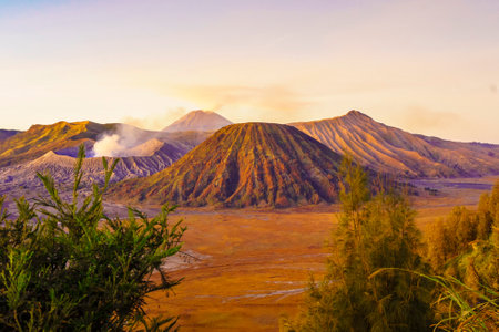 Dramatic sunrise over Mount Bromo, showcasing its volcanic cone and vast sand sea, creating a breathtaking landscape.の写真素材
