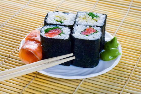 4 rolls of sushi with fish on the bambooの写真素材
