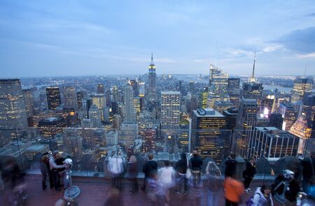 New York City, New York, USA - May 6, 2011:  Unidentifiable tourists view the Empire State Building and New York city skyline at dusk from the Top of The Rock observation deck in Rockefeller Center. Located in the center of Midtown Manhattan, Rockefeller のeditorial素材