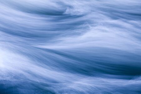 Rushing water in a river, toned blueの写真素材