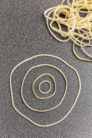 Rubber bands making a circular design on desktop, studio shotの写真素材
