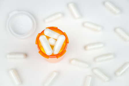 A prescription pill bottle filled to the top with medication, overhead viewの写真素材