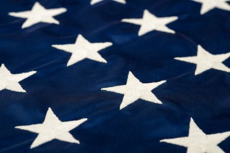 Closeup of the white stars embroidered on the American flagの写真素材