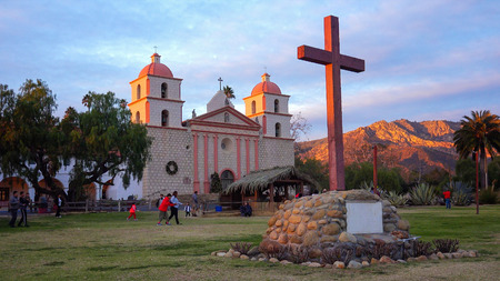 The last light of the setting sun hitting the bell towers of Old Mission Santa Barbara in Santa...