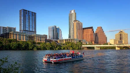 Austin, Texas skyline and tour boat packed with tourist on the Colorado Riverのeditorial素材