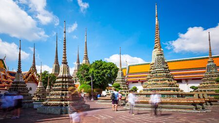 Tourists admire the many buddhist stupas at Wat Pho temple in Bangkok, Thailand (faces blurred for commercial use)のeditorial素材