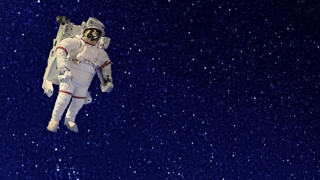 An astronaut in spacesuit floating in the blackness of space against a background of starsの写真素材