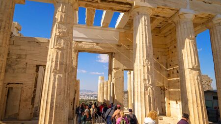 ATHENS, GREECE - April 12th: Tourists walking through columns of ancient Greek ruins at the Acropolis in Athens on April 12th, 2019.のeditorial素材