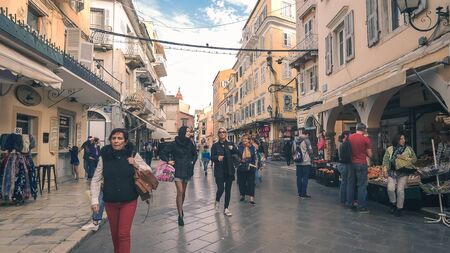 People walking and shopping on a street in old town Corfu, Greeceのeditorial素材