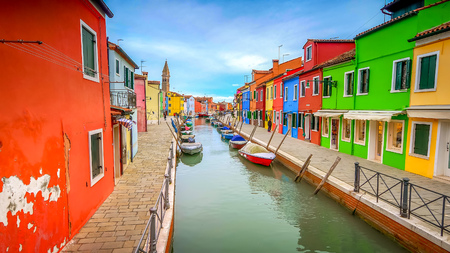Colorful fishermans homes dot either side of a canal  in the village of Burano in Venice, Italyの写真素材
