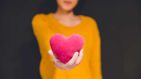 People, love, charity and family concept - close up of child hands holding red heart shape at homeの写真素材