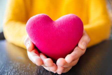 Young asian woman holding red heart model, Concept on take care your heart health, giving red heart. Valantine day.の写真素材
