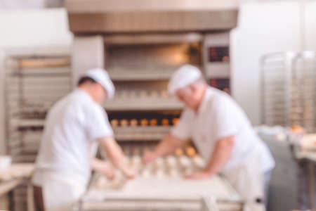 Blurred bakery shop in wholesale store with baking machine, oven, conveyor, production line, mixer and cooling plant. Modern food processing plant factory. Food industry backgroud. Vintage tone.の写真素材