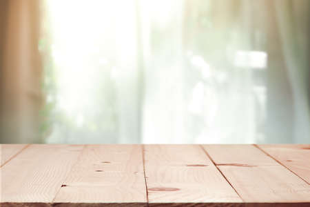 Rustic Wooden table on defocused curtain window and stationery box with sunlight .For montage product display or design key visual layoutの写真素材