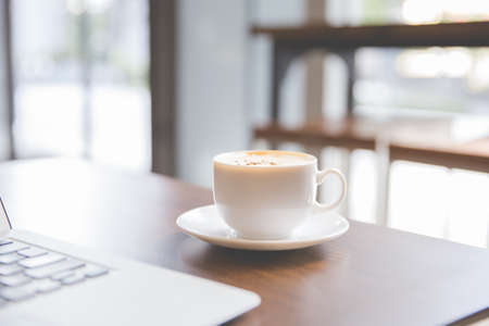 Coffee cup and laptop for business in coffee shop in the morningの写真素材