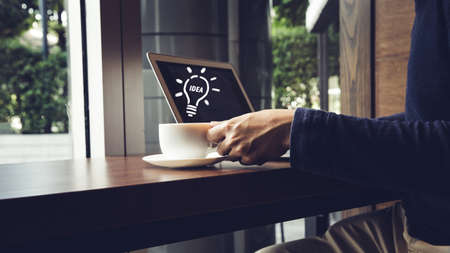 Selective focus of Side view laptop is on the work table in a conner office with morning light. idea...