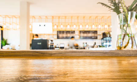 Selected focus empty brown wooden table and Coffee shop, cafe or restaurant blur background with bokeh image, for product display montageの写真素材