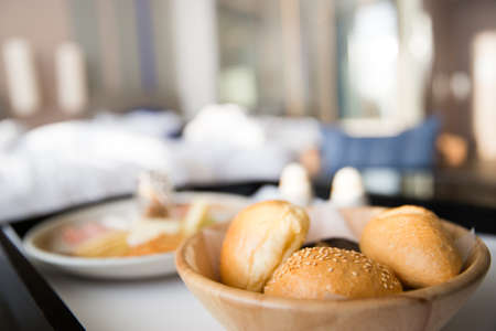 basket of various bread rolls and buns with blur abstract background. In room dining service.の写真素材