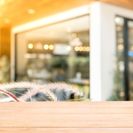 Empty wood table top with Abstract blurred restaurant window - vintage style picture with bokeh light.の写真素材