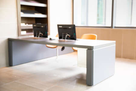 Blur of Open space office in modern style with the equipments, desk, computer, comfortable chair and document paper on the shelf.の写真素材
