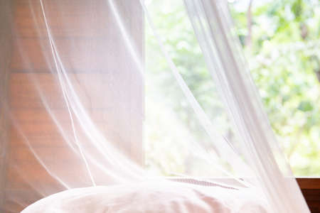 Vintage white mosquito curtain in a hut or house in a tropical hotel resort.の写真素材
