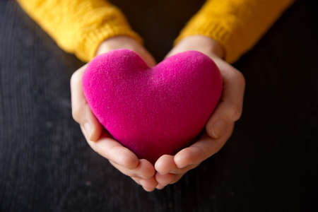 Young asian woman holding red heart model, Concept on take care your heart health, giving red heart. Valantine day.の写真素材