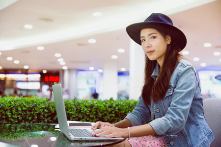 A young freelancer working in the workplace at the mall, using laptop.の写真素材