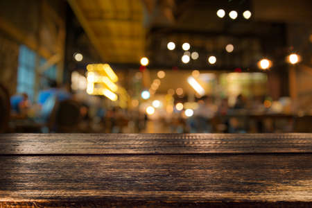 Real wood table with appetizer and light reflection on scene at restaurant, pub or bar at night. Blurred background for product display or montage your products with several concept idea and any occasion.の写真素材