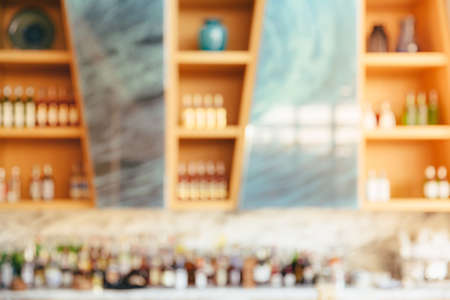 defocused background and bottles of Modern hotel lounge and bar with the shelfe of alcoholic drinks, cocktail and mocktail with fruite. Blur abstract Background concept.の写真素材