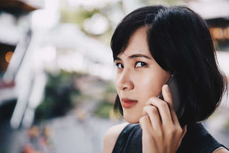 A  angly asian woman talking her mobile phone in the mall with a bitchy face. Technology communication concept.の写真素材
