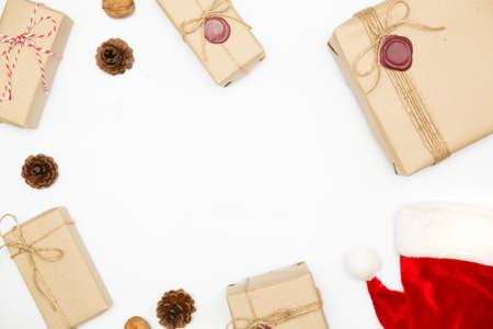 Gift box in vintage brown color and Christmas hat on isolated white background. Empty space for text ot product presentation.の写真素材