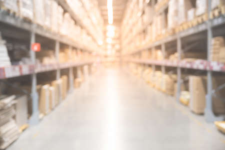 Blurred boxes on rows of shelves in warm light warehouse background.  Using for Mock up template for craft display of your design,Banner for advertise of product.の写真素材