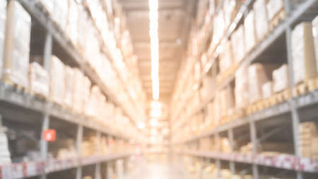 Blurred boxes on rows of shelves in warm light warehouse background.  Using for Mock up template for craft display of your design,Banner for advertise of product.の写真素材