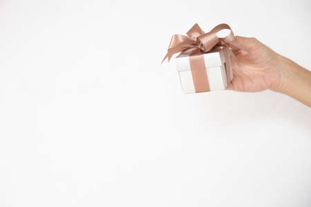 A female hand holding or giving a gift box with isolated white background.の写真素材