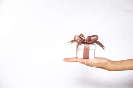 A female hand holding or giving a gift box with isolated white background.の写真素材