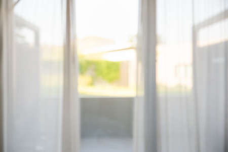 Defocused of curtain window with garden view in summer season. Background usage and space for your...