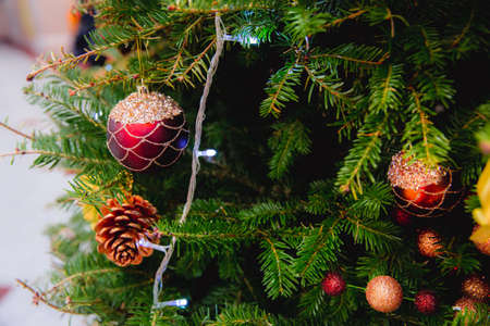 Beautiful decorated Christmas tree with toys, gift box, little pine, lights and bauble. Chritmas and...