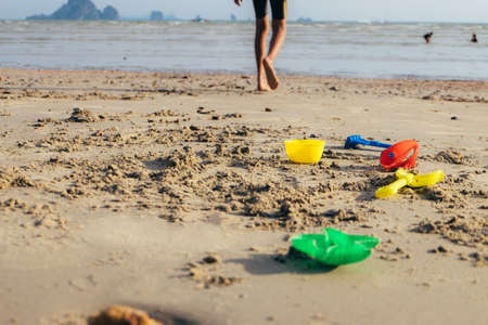 Happy boy playing beach toy and splashing in the sea beach. Kids having fun outdoors. Summer...