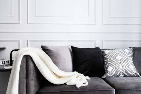 Living room interior with with gray fablic sofa, comfy pillows, plaid and knitting whithe blanket. Decoration modern  room interior design.の写真素材