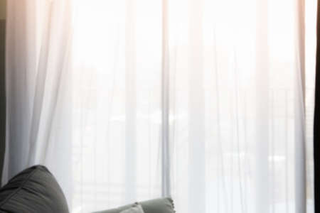 Blur of curtain window and pillow in livingroom with sunlight. For montage product display or design key visual layout.の写真素材