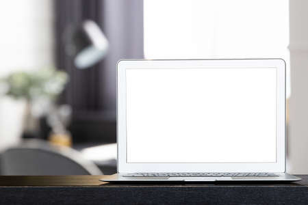 Mock up of blank modern laptop on the black desk. Personal laptop computer on dark wood table in modern white living room.の写真素材
