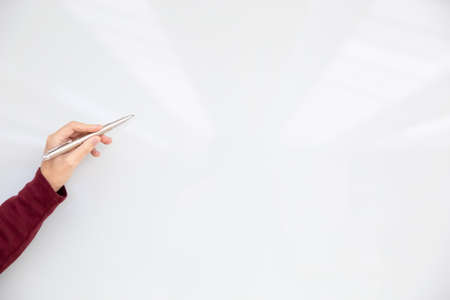 Female hand holding pen and pointing to the white board for new project presentation. Copy or empty space for text or product display.の写真素材