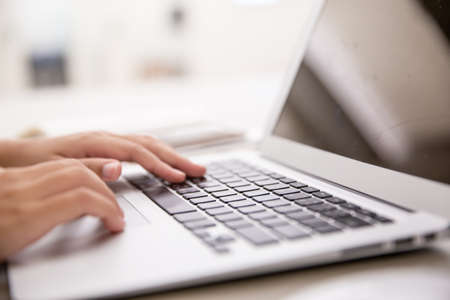 Side view of female hand typing keyboard  with copy space. Office table background ideas and business concept.の写真素材